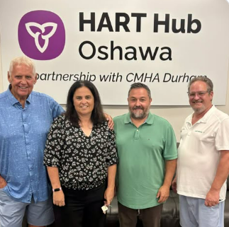 Dave Westlake with candidates and CMHA Durham staff in front of the HART Hub Oshawa sign